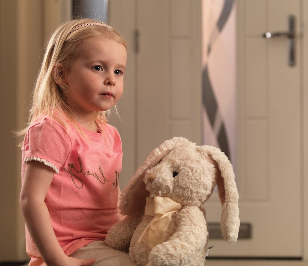 Girl sitting in hallway with composite door in the background